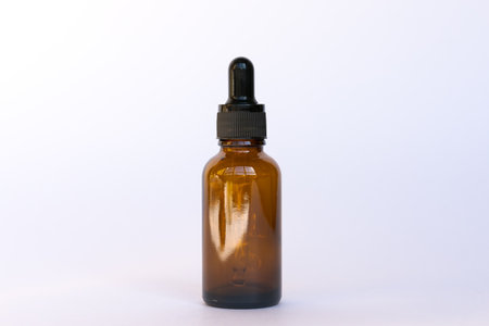 Amber glass cosmetics bottle with dropper, white background. Natural skin care SPA beauty product product design.の写真素材