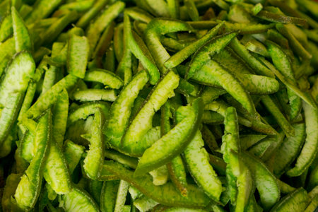 Close-up of a pile of dried green citrus peels on a plain background. Concept of natural food...