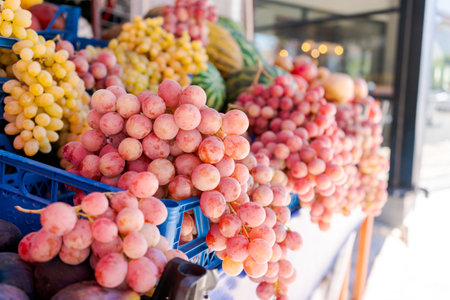 Bunches of grapes in different colors displayed on a market stand. Fresh produce background. Concept of healthy eating and organic foodの写真素材