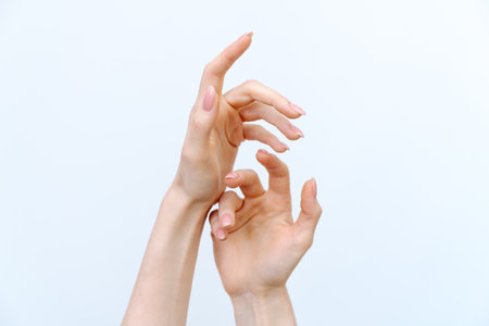 Two hands are shown with a white background. The hands are positioned in a way that they are touching each other, but not overlapping. Concept of connection and intimacy between the two peopleの写真素材