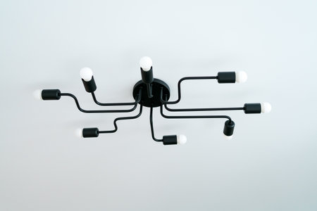 Black light fixture with six lights on it. The lights are all on and the fixture is hanging from the...