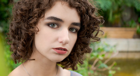 Woman with brown hair and green eyes. She is wearing a necklace. She is looking at the cameraの写真素材