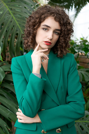 Woman in a green jacket is posing for a photo. She is wearing a watchの写真素材