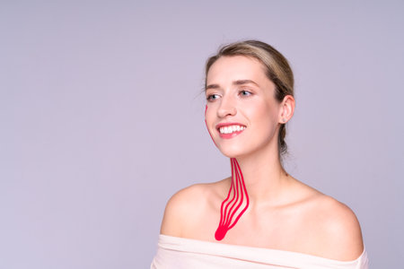 Photograph of the anatomy of the skin of the face and neck on a young woman with red tape lines...