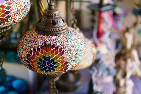 Colorful glass lamp with a gold base. The lamp is on display in a store. There are other lamps in...