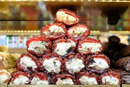 Stack of red pastries with nuts on top. The top pastry is the largest. There are many pastries in the stackの写真素材