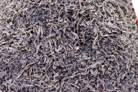 Pile of black tea leaves. The leaves are piled on top of each other. The pile is very large