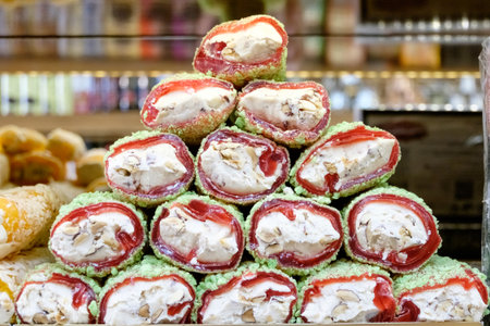 Stack of pastries with green and red toppings. The top pastry is greenの写真素材