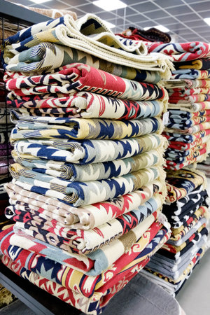 Stack of colorful blankets are on display. The blankets are in different colors and patterns. There...