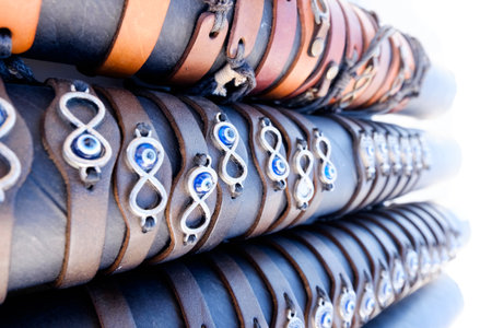 Stack of bracelets with blue beads and a silver symbol. The bracelets are stacked on top of each otherの写真素材