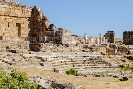 Stone structure with steps and pillars. The area is surrounded by stone walls. There are several pillars in the areaの写真素材