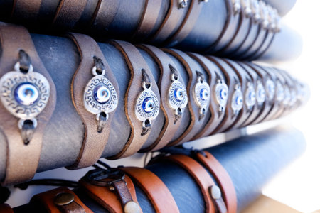 Row of bracelets with blue beads on them. Some are brown and some are black. They are all lined upの写真素材