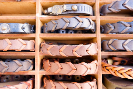 Wooden box with a variety of bracelets. The bracelets are made of leather and have a braided designの写真素材