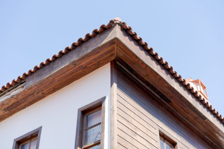 Corner of ottoman house with terracotta roof tiles and wooden eave low angle at sky. Suitable for ottoman heritage, traditional architecture and travel real estate.