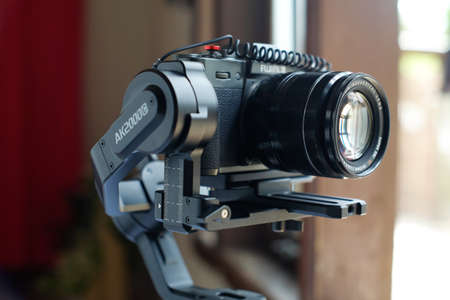 Lampung, Indonesia, March 30, 2022: Modern mirrorless camera on 3-axis gimbal stabilizer with camera-attached recording cable and stabilizer, Designed for video captureのeditorial素材