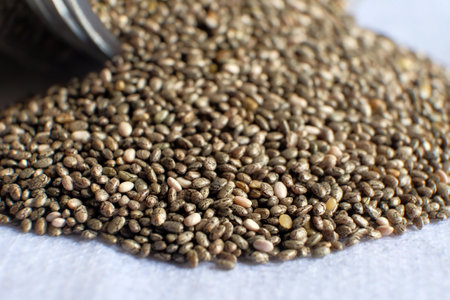 Detail of chia seeds scattered in pile on white background.の写真素材