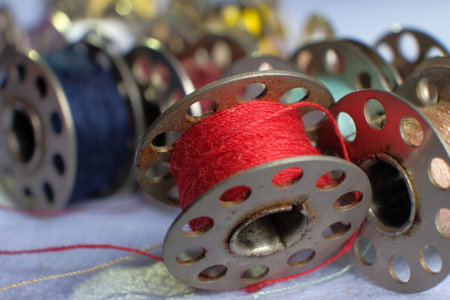 Multicolored threads on the bobbin from the sewing machine on a blurred background from the other bobbinsの写真素材