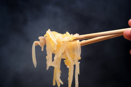 chopsticks holding noodles on a black background, close-upの写真素材