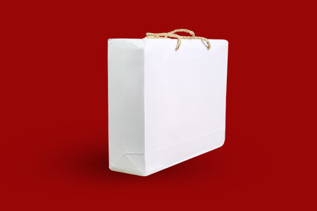 White paper bag isolated on red background. Clipping path included.の写真素材