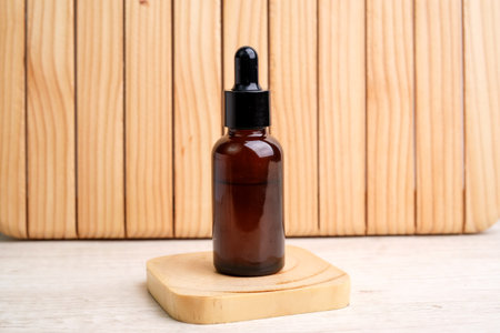 A glass vial filled with serum stands on a wooden box.の写真素材