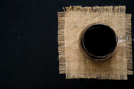 Coffee cup and sack on black background, top view.の写真素材