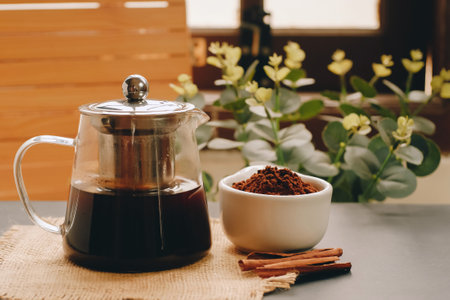 Coffee pot with ground coffee and cinnamon on the table.