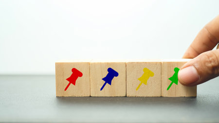 Wooden block with push pin on white background, business concept.の写真素材