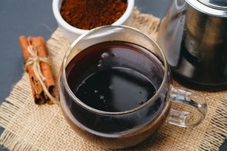 Coffee in a glass cup on a black background. Coffee beans and ground coffee.の写真素材