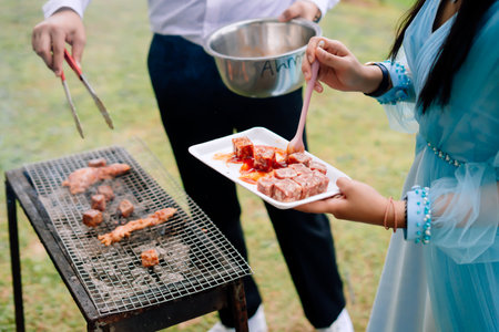 Man and woman preparing a barbecue in the park. Close-upの写真素材