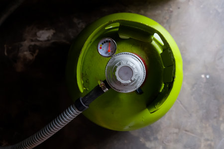 Green gas cylinder with a gauge on a concrete background. Top view.の写真素材
