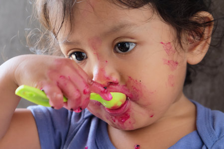 Cute asian baby girl playing with her toothbrush with blood.の写真素材