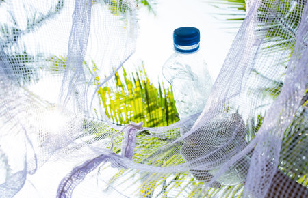 plastic bottle of mineral water in hammock on palm tree backgroundの写真素材