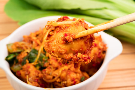 spicy stir fried chicken meatballs in a bowl on wooden tableの写真素材