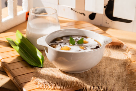 Bubur Candil or Indonesian rice flour porridge with sweet potato sticky rice balls, served with palm sugar sauce in a white bowlの写真素材