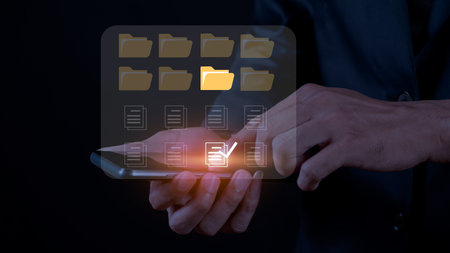Businessman holding mobile phone with folder icon on screen, Business technology conceptの写真素材