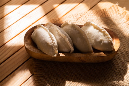 Fried dumplings in a wooden plate on a wooden tableの写真素材