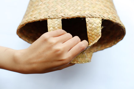 hand holding bamboo basket on white background, closeup of photo.の写真素材