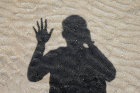 Shadow of a man in the sand. The concept of silence and silence.の写真素材