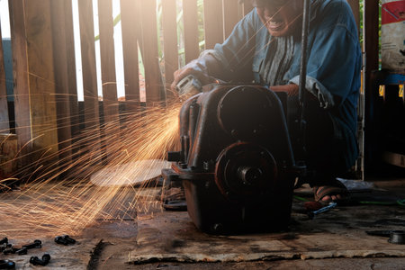 Worker cutting metal with angle grinder in factory, selective focusの写真素材