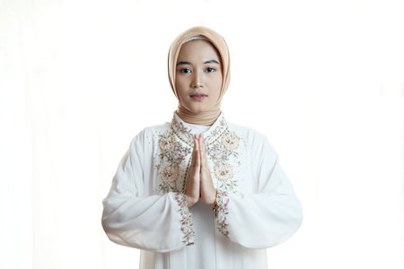 Portrait of Asian muslim woman with praying gesture on white backgroundの写真素材