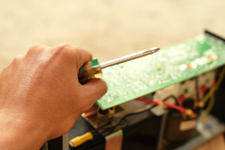 Repairman repairing a circuit board with a screwdriver, closeupの写真素材