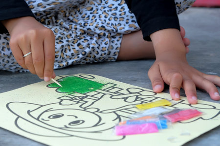 Child drawing with felt-tip pens on a piece of paper.の写真素材