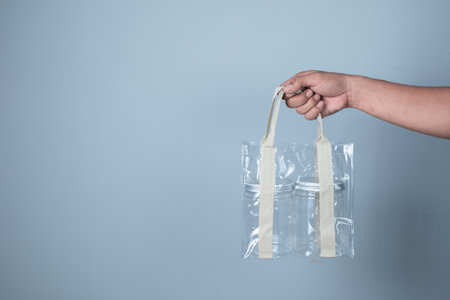 Hand-holding plastic bag on blue background, Recycling concept.の写真素材