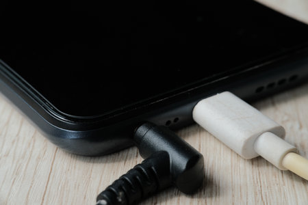 Close up of black smartphone with power bank on wood table background.の写真素材