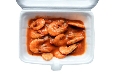 Prawns in tomato sauce in a plastic box isolated on white backgroundの写真素材