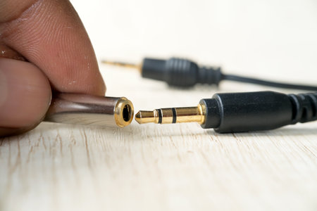 Close-up of a man's hand holding an audio jack.の写真素材