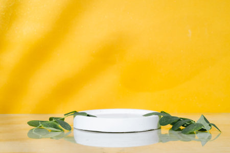 Cosmetic cream with eucalyptus leaves on yellow backgroundの写真素材