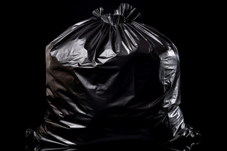 Black trash bag isolated on black background. Ai generativeの素材