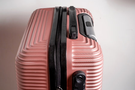 Minimalist travel luggage bag in peach color isolated on white background. Cabin size luggage...
