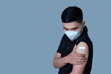 Vaccinated Asian adult man showing adhesive plaster bandage on his arm after anti-virus injection. I've Got the Vaccineの写真素材